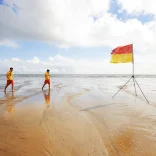Two lifeguards walking across the beach